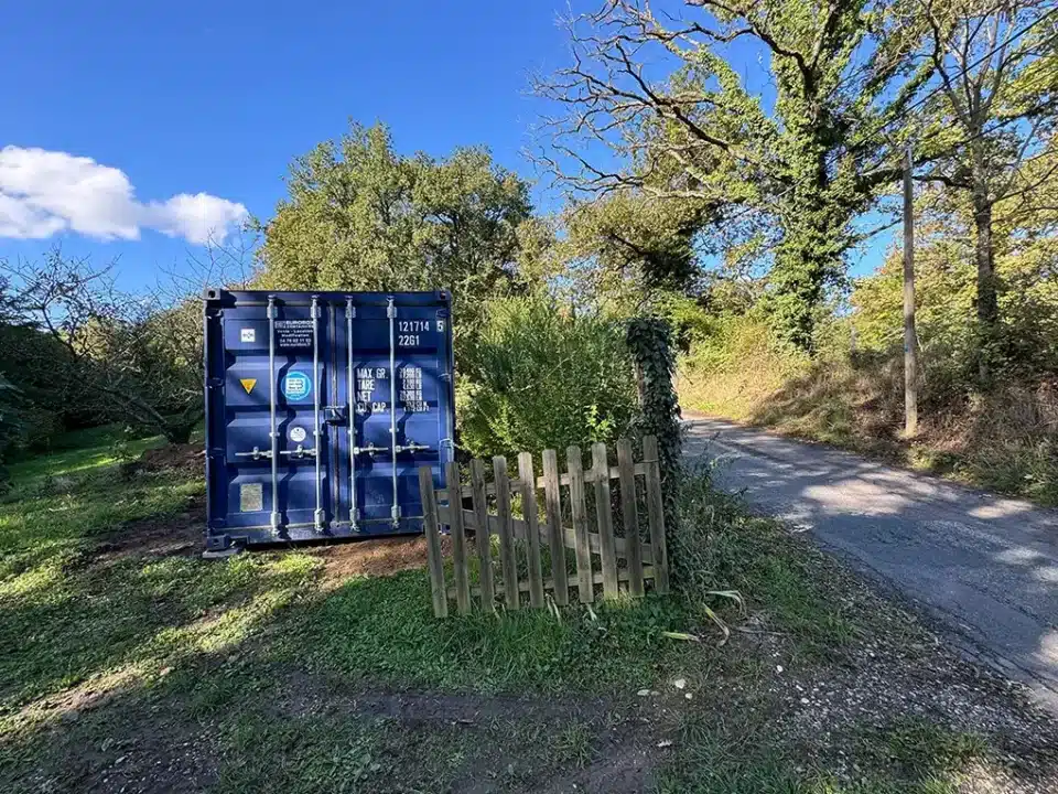 Livraison d'une conteneur maritimes bleu 20 pieds sur un terrain par Eurobox spécialisé dans le conteneur maritime , en vente et location